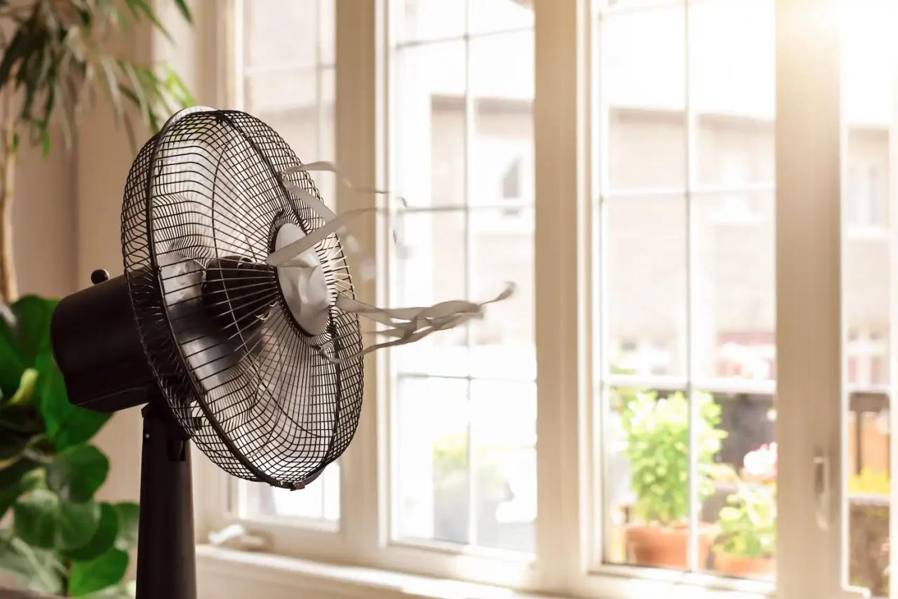 Electric cooling fan with ribbons blowing in front of the window on a hot summer's day in Segovia